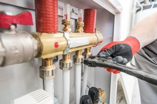 Heating specialist working with pipe fittings and valves