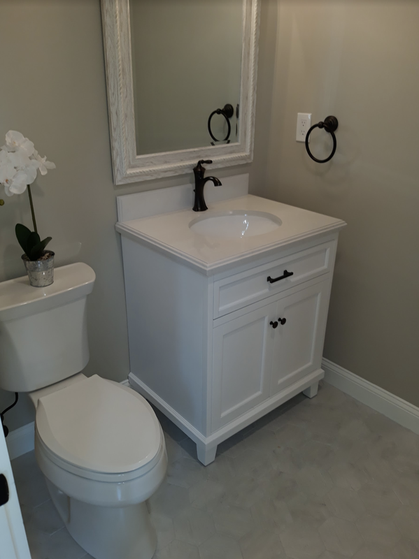 Bathroom remodel toilet and small white vanity installation