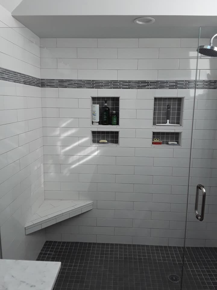 Subway tile with gray niche and accent tiles, and built in seat